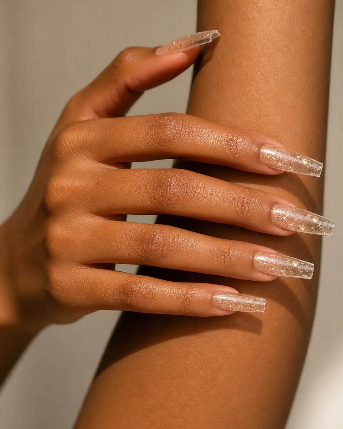 Long coffin acrylic nails with champagne glitter encapsulated inside clear acrylic