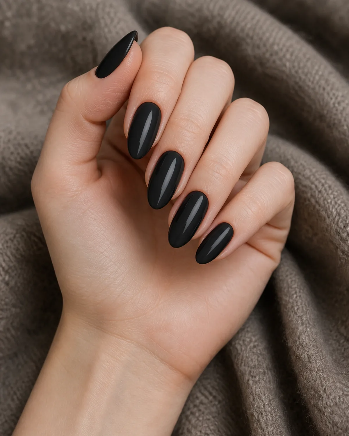 Soft charcoal-black cream on long almond nails