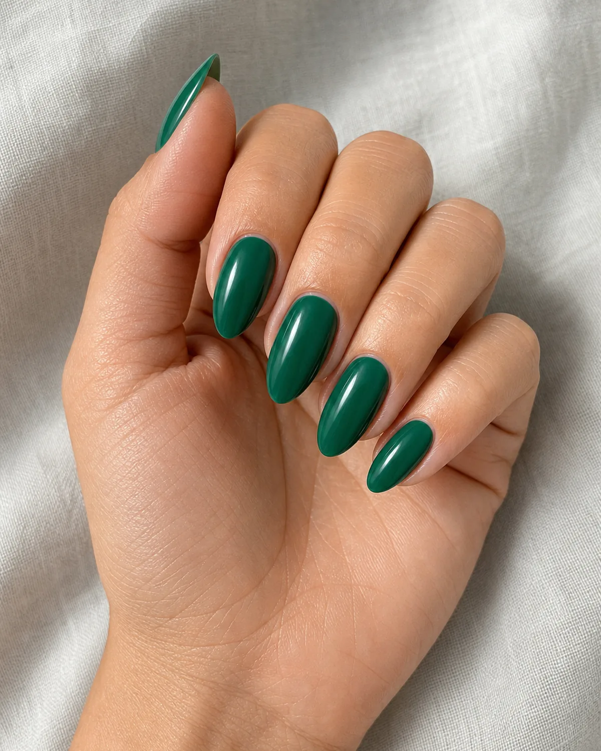 Jewel-toned emerald cream on medium almond nails