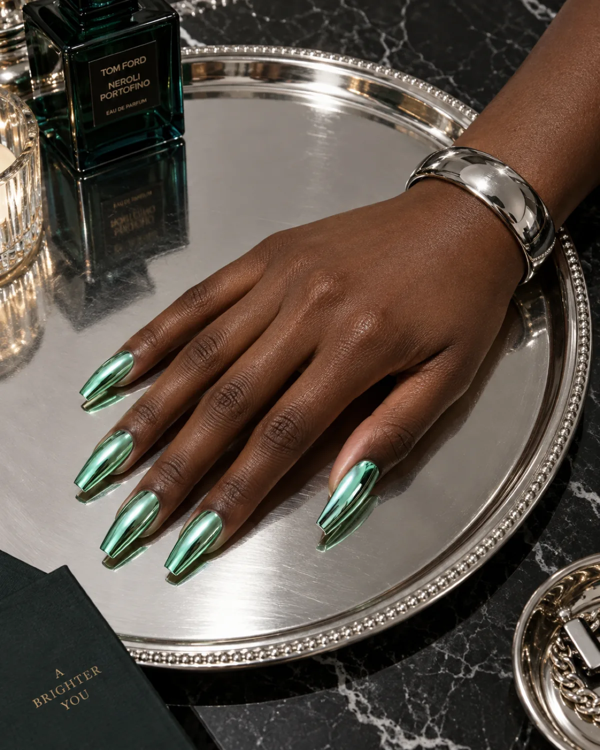 Chrome mint green mirror finish nails on coffin shape on round silver tray deep skin tone
